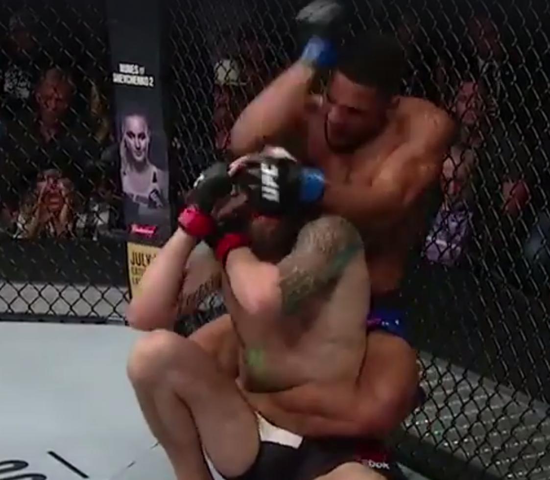 Kevin Lee lấy lưng Michael Chiesa và tung chỏ, rất may đó không phải 1 cú chỏ 12-6, tuy nhiên nó cũng rất nguy hiểm (ảnh cắt từ video) UFC, MMA, chỏ cắm, chỏ 12-6, Eddie Alvarez vs Dustin Poirier, đòn cấm trong MMA, Conor McGregor, John McCarthy